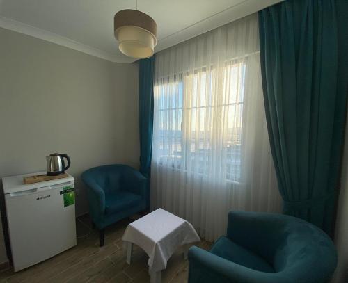 エドレミトにあるVesta Butik Otelの青い椅子2脚と窓が備わる客室です。