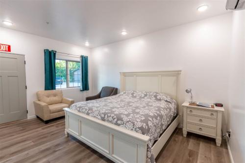 a bedroom with a bed and a chair and a dresser at Hurricane Hideaway Lodging in Hurricane