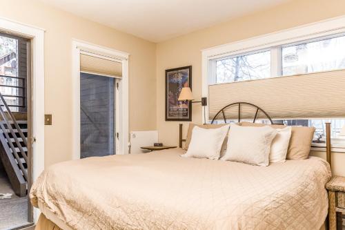 um quarto com uma cama com lençóis brancos e janelas em Viking Lodge em Telluride