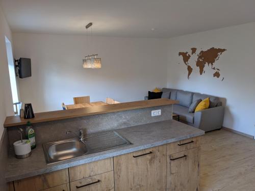 eine Küche mit einem Waschbecken und einem Sofa in einem Zimmer in der Unterkunft Ferienwohnung MonSevi in Wackersberg