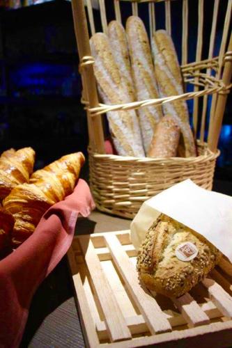 a table with a basket of bread and a basket of pastries at Kyriad Restaurant Centre SPA Vichy in Vichy