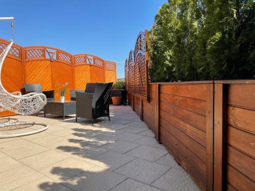 a patio with a wooden fence and a table and chairs at Apartamenty Blisko Centrum in Toruń