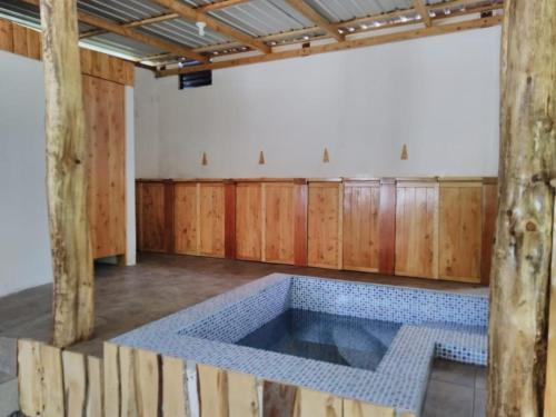 a large tub in a room with wooden walls at Casa del Peregrino Santo Thomas in Baños
