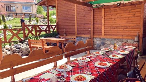 a long table with plates of food on a patio at Тихият кът in Sapareva Banya