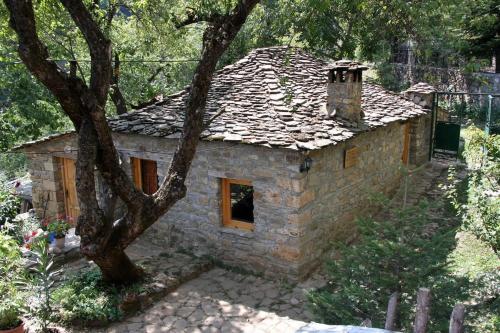 a small stone house with a window in a yard at Guest House Ktona in Dardhë