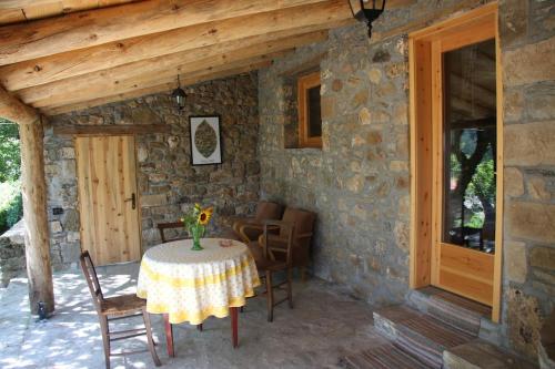 達爾德的住宿－Guest House Ktona，一座石头房子,在庭院里配有桌椅