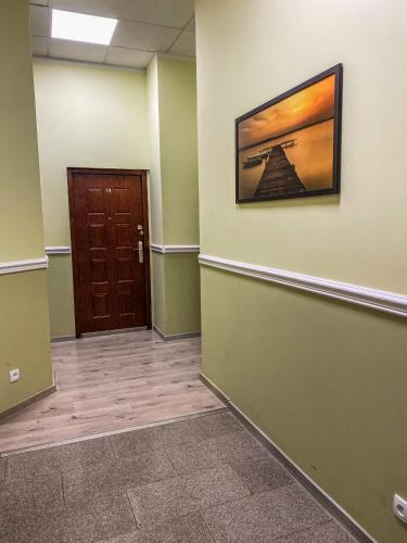a hallway with a door and a picture on the wall at Apartamenty Olsztyn in Olsztyn