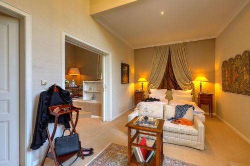 a living room with a bed and a table at Schlosshotel Hugenpoet in Essen