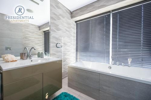 a bathroom with a tub and a sink and a window at Prezydencki Apartamenty z widokiem na morze in Jarosławiec