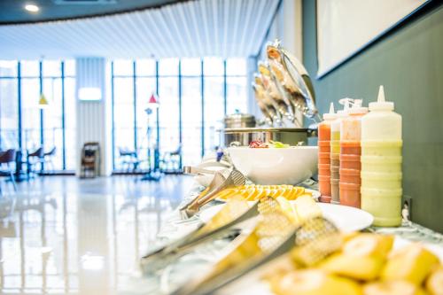 a counter with plates of food and bottles of juice at Hotel Stayon in Geoje 