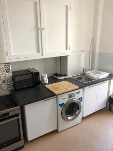 a kitchen with a washing machine and a microwave at La Promenade House in Nice