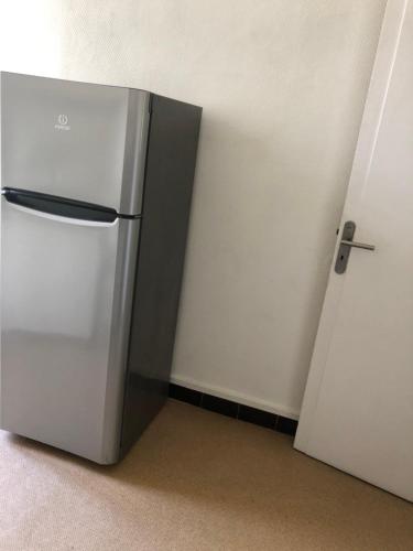 a white refrigerator in a room next to a door at La Promenade House in Nice