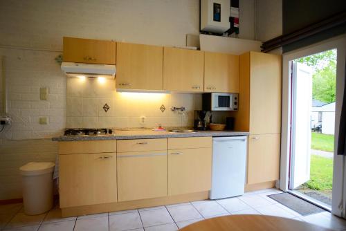 a kitchen with yellow cabinets and a white refrigerator at Vakantie Zuid Limburg in Simpelveld