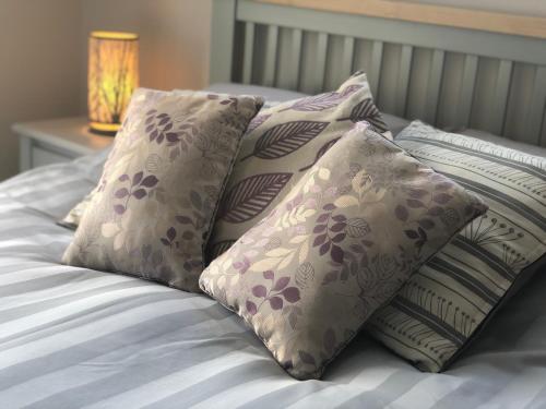 - une pile d'oreillers au-dessus du lit dans l'établissement Hunters Lodge Apartments, à Ballachulish