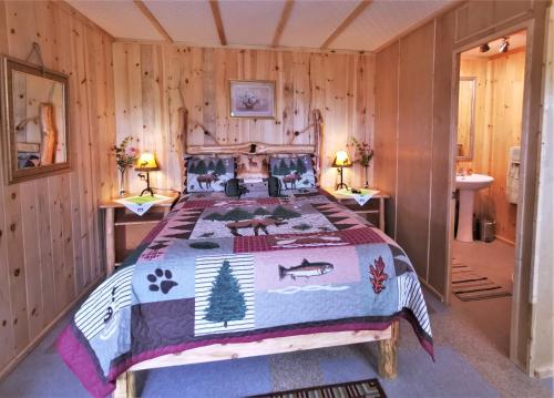 een slaapkamer met een bed met een quilt bij WildExodus Outdoors in Timmins