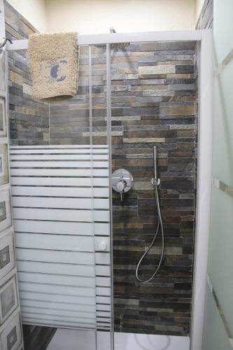 a bathroom with a shower with a tile wall at Lightroom in Fenis