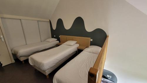three beds in a room with a wall with a bat sign at Gold Beach Hotel & RESIDENCE in Asnelles