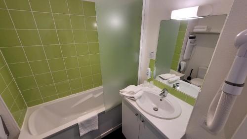 a bathroom with a sink, toilet, and bathtub at Gold Beach Hotel & RESIDENCE in Asnelles