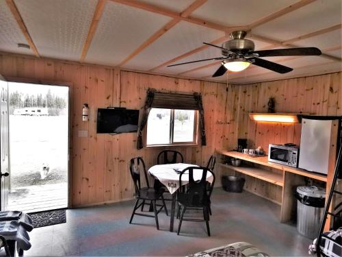 eine Küche mit einem Tisch und Stühlen sowie einem Deckenventilator in der Unterkunft WildExodus Outdoors in Timmins