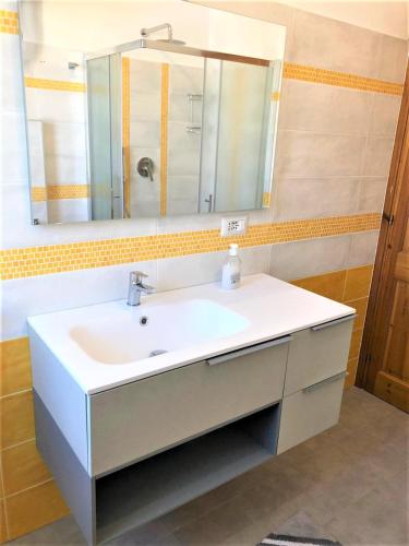 a bathroom with a white sink and a mirror at Casa Verde in Cala Gonone