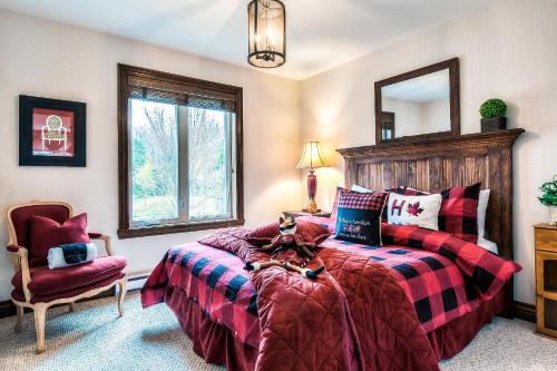 1 dormitorio con 2 camas, silla y espejo en Townhouse On The Golf La Bte -10min To Tremblant en Mont-Tremblant