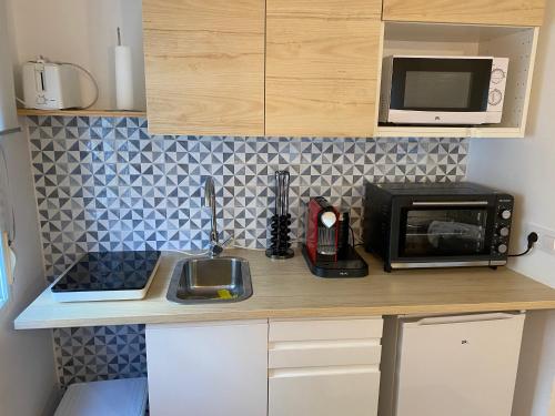 a kitchen counter with a microwave and a sink at Duplex Casco Histórico in Pontevedra