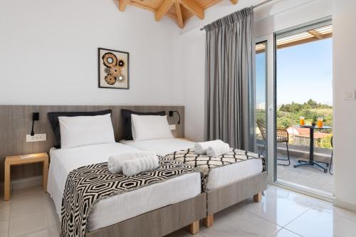 a bedroom with a large bed and a balcony at L & C Boutique Apartments in Kremasti