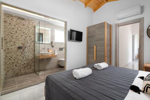 a bedroom with a shower and a bed with two towels at L & C Boutique Apartments in Kremasti