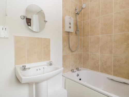 ein Badezimmer mit einer Dusche, einem Waschbecken und einer Badewanne in der Unterkunft Teal in Cote