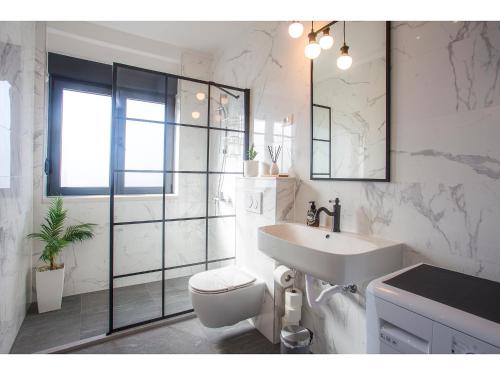 a white bathroom with a toilet and a sink at Boutique City Center View Apartments in Split