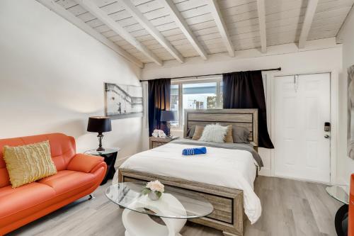 a bedroom with a bed and a couch and a table at Coral Sands Boutique Lux Studio in West Palm Beach
