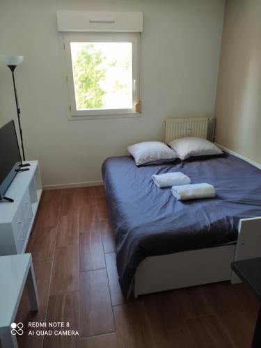 1 dormitorio con 1 cama con 2 almohadas y ventana en Charmant studio avec piscine et clim (en été) en Aix-en-Provence