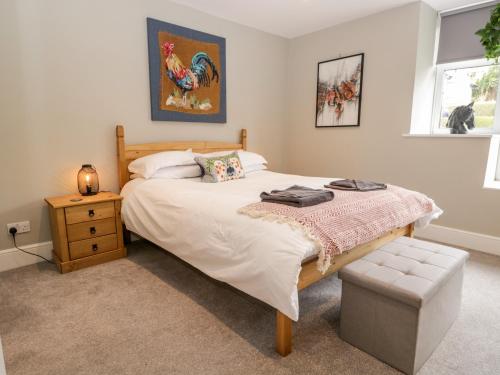 a bedroom with a large bed and a night stand at Walker's Cottage in Windermere
