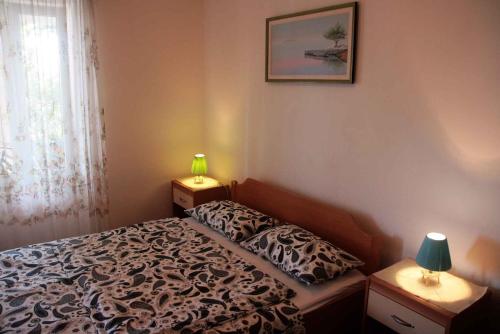 a bedroom with a bed and two night stands with lamps at Apartment in Silo/Insel Krk 14603 in Šilo