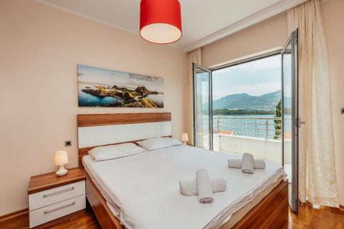 a bedroom with a bed and a large window at Apartmani Jelena in Tivat