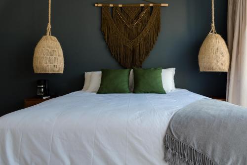 a bedroom with a white bed with green pillows at Sanyama Holbox in Holbox Island