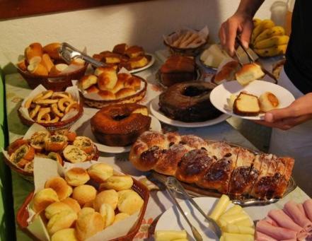 un tavolo pieno di diversi tipi di cibo su piatti di Espaço Vilarejo Pousada a Serra do Cipo
