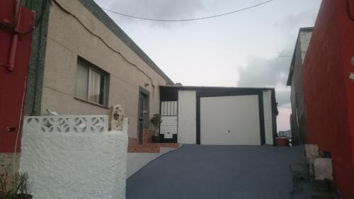 alejka z białymi drzwiami i budynkiem w obiekcie Casa Relajación w mieście Santa Cruz de Tenerife