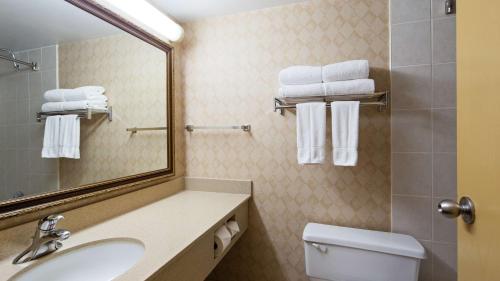 uma casa de banho com lavatório, espelho e toalhas em Best Western North Bay Hotel & Conference Centre em North Bay