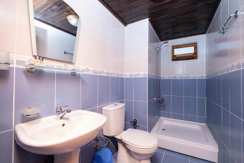 a bathroom with a white toilet and a sink at Fifties Corner in Olympos