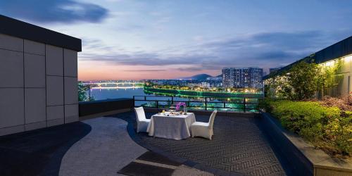 a table and chairs on a balcony with a view at Crowne Plaza Huangshan Yucheng by IHG in Huangshan