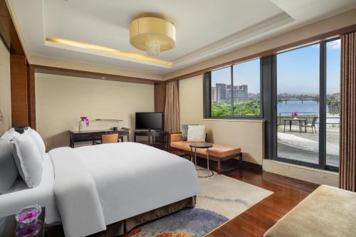 a bedroom with a large white bed and a large window at Crowne Plaza Huangshan Yucheng by IHG in Huangshan