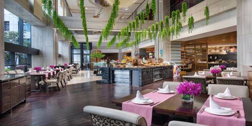a restaurant with pink tables and chairs and a bar at Crowne Plaza Huangshan Yucheng by IHG in Huangshan