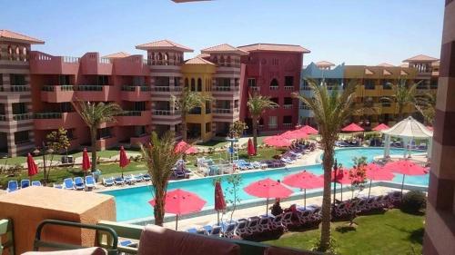 a view of a resort with a pool and pink umbrellas at Porto al Sokhna 411001 fully equipped ground floor sea view in Ain Sokhna