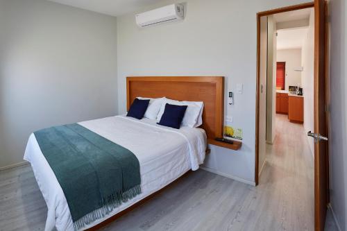 um quarto com uma grande cama branca com almofadas azuis em Casa Palo Verde em Cabo San Lucas