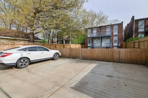 a white car parked in a driveway next to a wooden fence at 1 Bd Apt near forest park, Science Center & dining in Tower Grove