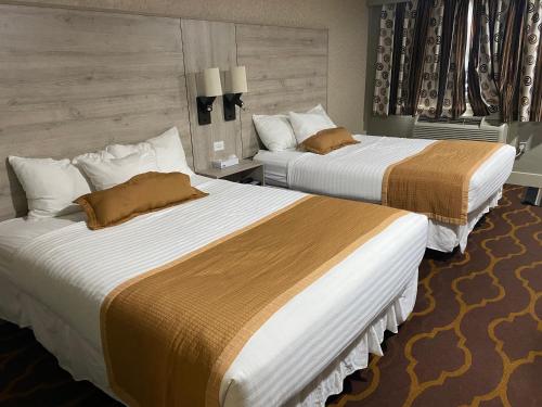 two beds in a hotel room with two beds at Ramada by Wyndham Medicine Hat in Medicine Hat