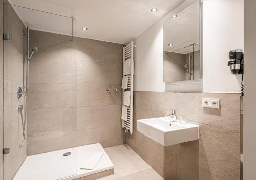 a bathroom with a sink and a shower at Hotel Stachus in Munich