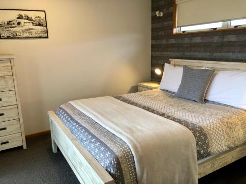 a bedroom with a large bed and a dresser at The Snug in Twizel
