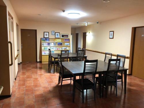 a dining room with a table and chairs at Alpine Guesthouse in Furano